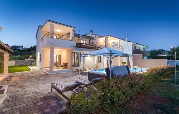 A modern two-story house with a swimming pool, outdoor seating, and a covered patio area. - Awesome home in Stinjan (Stinjan)