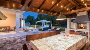 An outdoor patio with a hot tub, lounge chairs, and a covered seating area. - Awesome home in Stinjan (Stinjan)