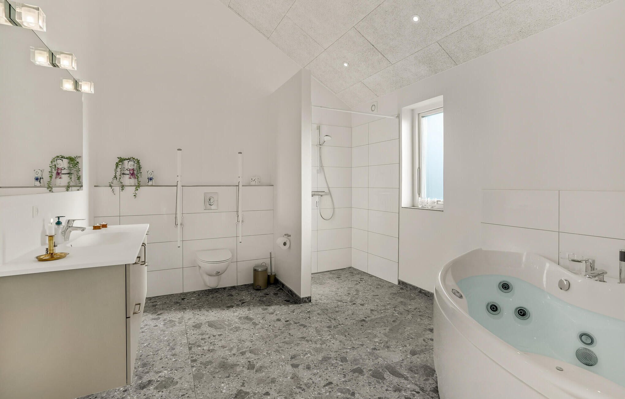 Un baño moderno con una bañera independiente, ducha e inodoro.