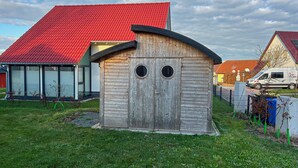 Ein Holzschuppen mit zwei Rundfenstern und einem gewölbten Dach.