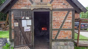 Ein rustikales Backsteingebäude mit einer Holztür und einem Schild darüber.