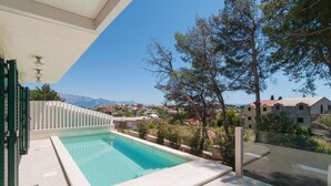A swimming pool with a view of a residential area and mountains in the background. - Cozy home in Sumartin (Sumartin)