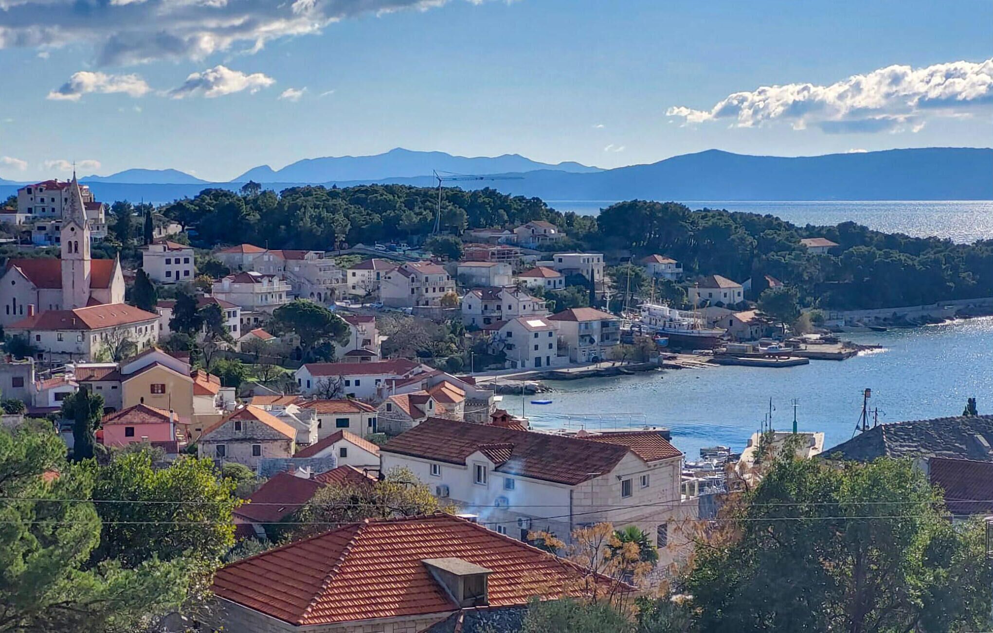 A coastal town with a prominent church, residential buildings, and a marina.