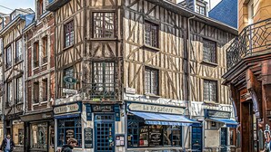 Un edificio tradizionale con struttura a graticcio e diverse vetrine, tra cui una panetteria e un caffè.