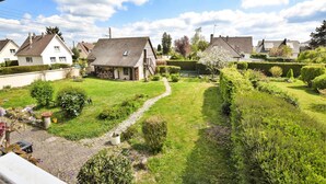 Un quartiere residenziale con case, un prato e un vialetto lastricato.