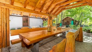 A rustic wooden pavilion with a stone floor, a wooden bench, and a picnic table. - Beautiful home in Breze with WiFi (Breze)