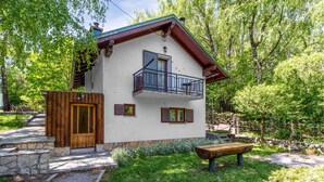 A two-story house with a balcony, stone steps, and a wooden bench. - Beautiful home in Breze with WiFi (Breze)