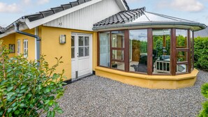 A yellow house with a white door, a small porch, and a glass conservatory. - Stunning home in Haderslev with WiFi (Haderslev)