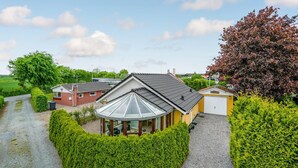 A house with a sloped roof, a garage, and a well-maintained garden. - Stunning home in Haderslev with WiFi (Haderslev)