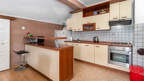 A kitchen with a wooden countertop, a sink, a stove, and cabinets.