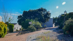 A paved pathway leading to a building with a sign indicating directions to nearby locations. - Lovely home in Estepa with house a panoramic view (Estepa)