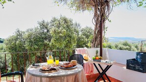A balcony with a table set for breakfast, including croissants, a pitcher of orange juice, and a fruit bowl. - Lovely home in Estepa with house a panoramic view (Estepa)