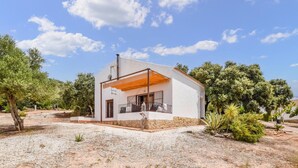 A white building with a covered patio and a stone base. - Lovely home in Estepa with house a panoramic view (Estepa)