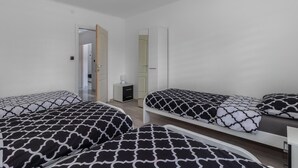 Une chambre avec deux lits, une table de chevet et une armoire.