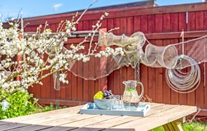 Enjoy a casual outdoor dining experience with a picnic table set amidst a serene garden view.