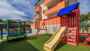 A playground with a slide, swings, and climbing structures.