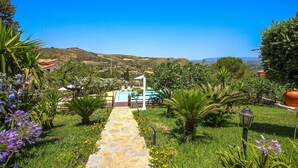 A stone pathway leading to a pool area surrounded by lush greenery and flowering plants. - 6 bedroom beautiful home in Perdifumo (Perdifumo)