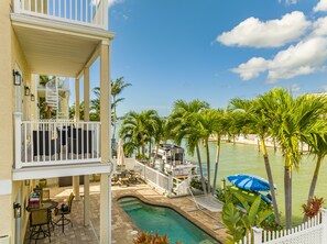A pool area with a hot tub, outdoor furniture, and a view of the water. - BEACH HOUSE GETAWAY! BEAUTIFUL WATER VIEWS & SUNSETS! PERFECT LOCATION! (Madeira Beach)