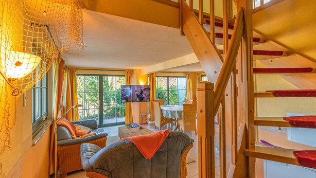 A cozy living room with a sofa, a television, and a dining area with a table and chairs. - 2 bedroom gorgeous home in Zierow OT Eggerstorf (Zierow OT Eggerstorf)