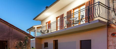 Ein zweistöckiges Gebäude mit Balkon, einer Tür und einem Fenster.
