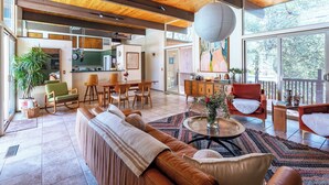 Un salón amplio con un sofá grande, una mesa de comedor y una cocina al fondo.