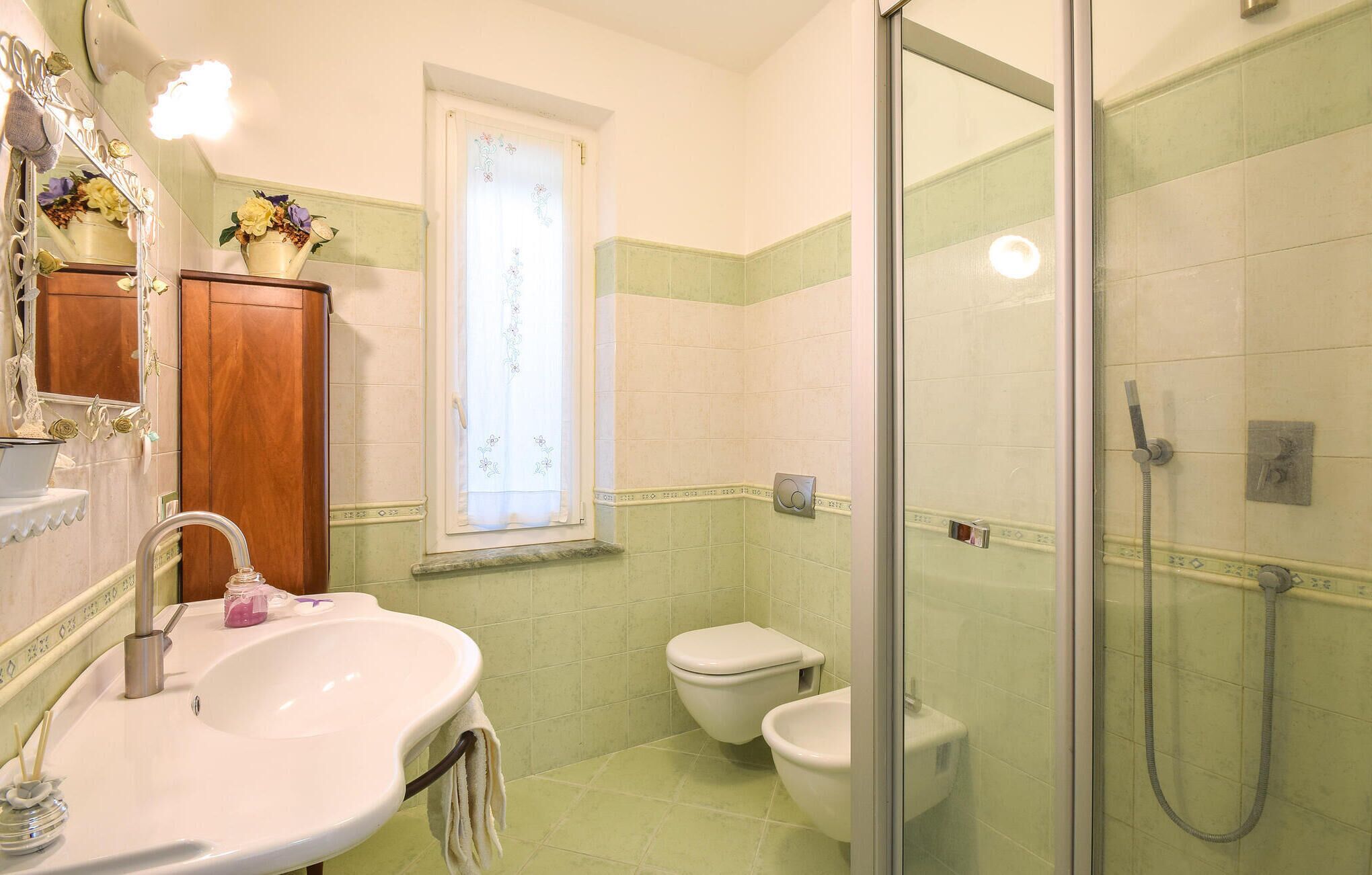 A bathroom with a sink, toilet, and shower.