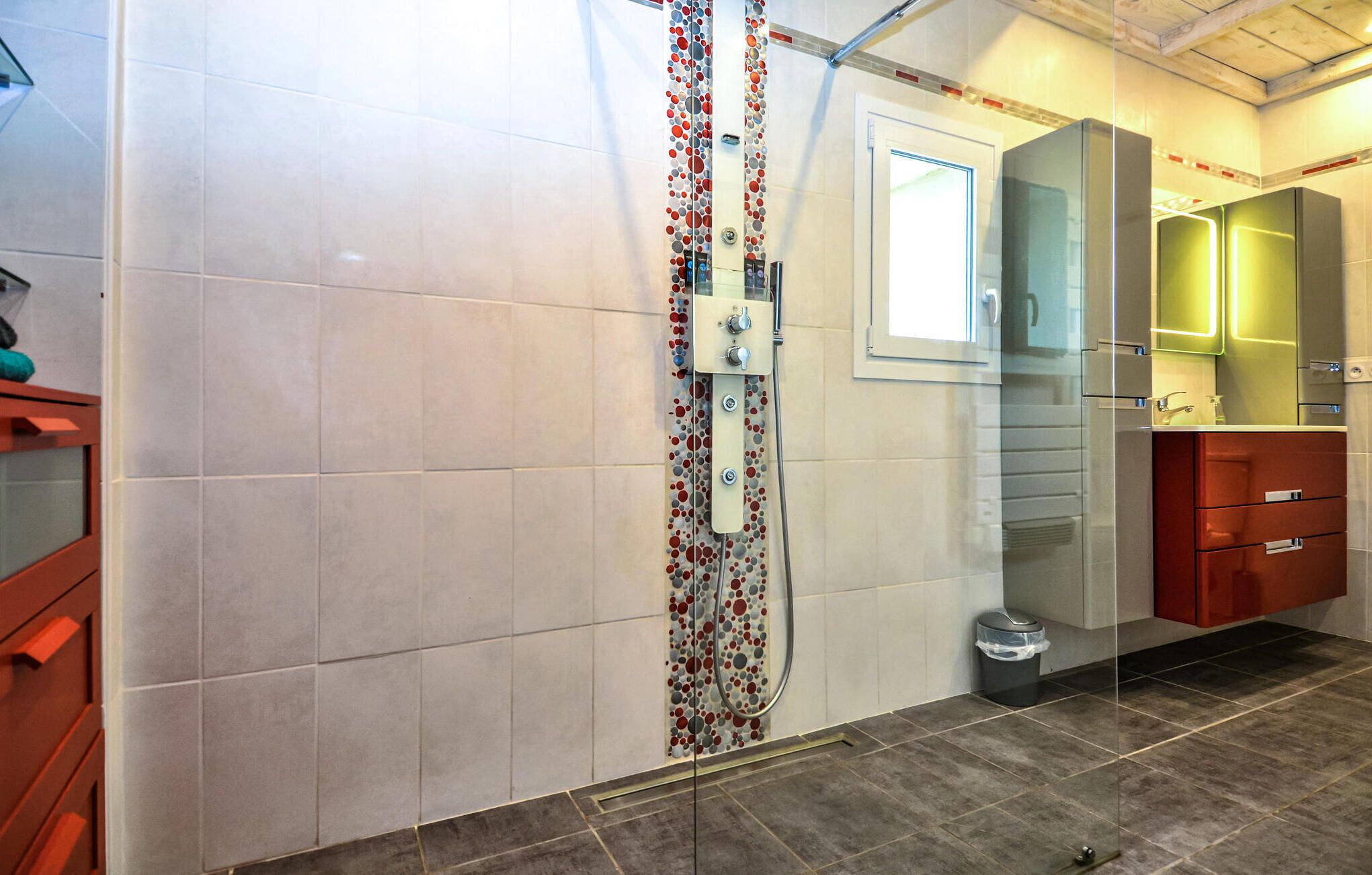 Ein Badezimmer mit Dusche, Spiegel und Toilette.