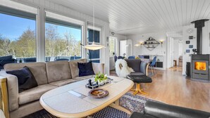 Un salon moderne avec un canapé, une table basse et une cheminée.