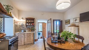 Une cuisine avec une table en bois, une cuisinière et un réfrigérateur.