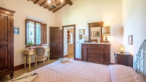 Une chambre à coucher avec un grand lit, des meubles en bois, un bureau et un miroir.