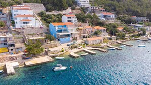 A coastal town with buildings along the waterfront, boats docked, and clear blue water.