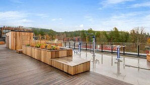 Eine Holterrasse mit Sitzgelegenheiten und Blick auf ein bewaldetes Gebiet.