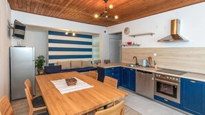 Eine moderne Küche mit blauen Schränken, einem Holztisch und einem eingebauten Backofen.