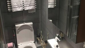 Ein modernes Badezimmer mit Toilette, Waschbecken und Handtuchhaltern.