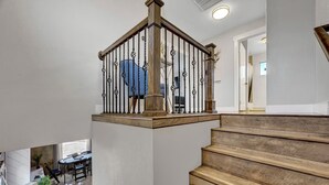 Eine Holztreppe mit Metallgeländer, die zu einer Zwischenebene führt.
