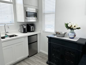 A modern kitchen with a stainless steel microwave, coffee maker, and dishwasher.