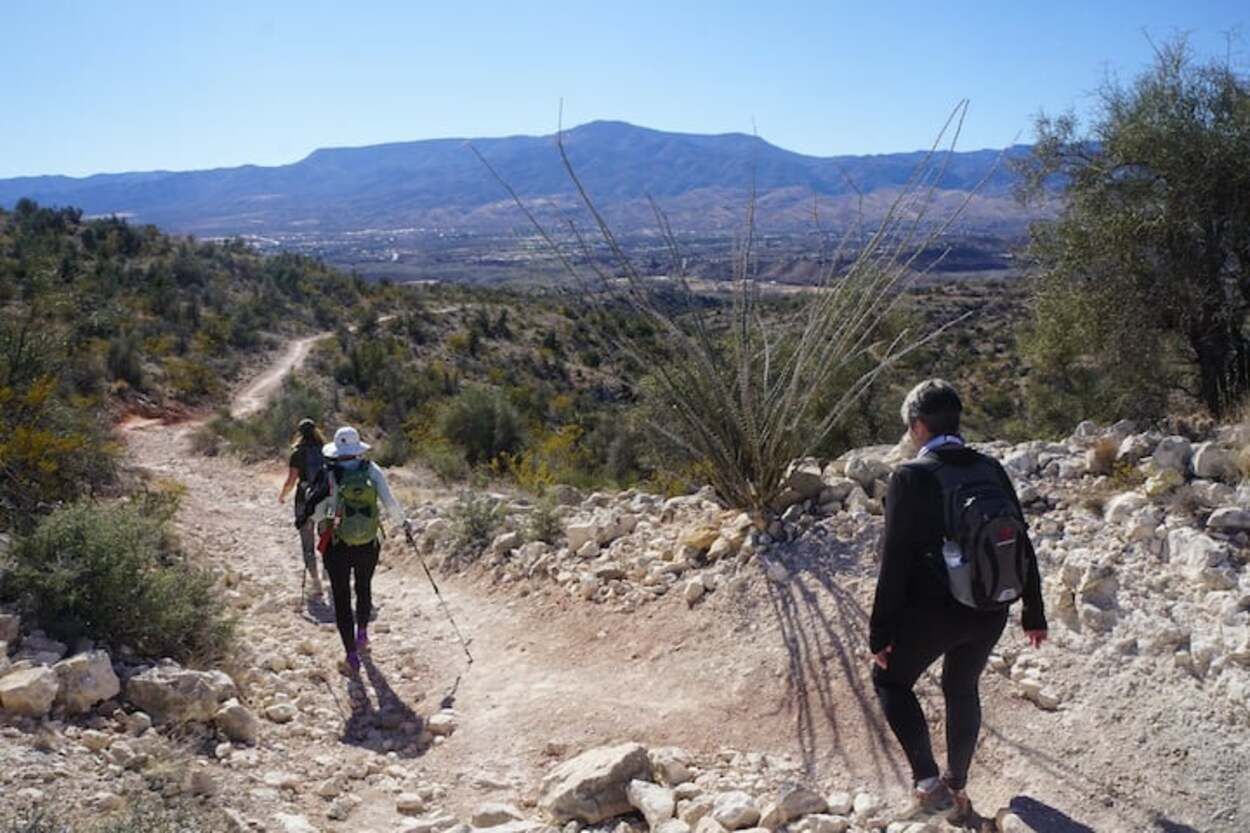 A rocky hiking trail with hikers in the distance.
