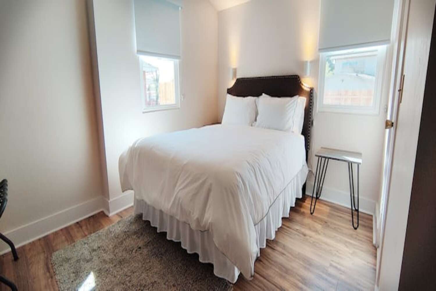Une chambre avec un grand lit, une petite table et une fenêtre.