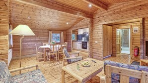 L’intérieur d’un chalet en bois comprend un coin repas, une cuisine et un espace salon.
