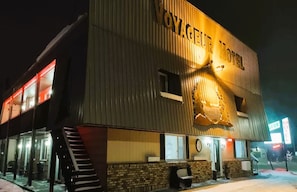 A building with a sign reading "VOYAGEUR HOTEL" and a neon sign for a motel. - Love Hotels Voyageur by OYO at International Falls MN (International Falls)
