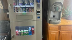 Una máquina expendedora con un dispensador de café y una señal de salida.