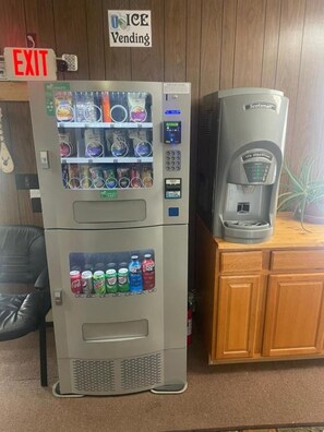 A vending machine with a coffee dispenser and an exit sign. - Love Hotels Voyageur by OYO at International Falls MN (International Falls)