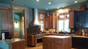 Una cocina con armarios de madera, una isla central, una estufa y un ventanal.