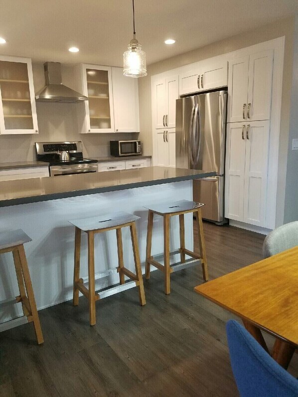 Enjoy meals in this well-lit kitchen with a refrigerator, microwave, and dining table.