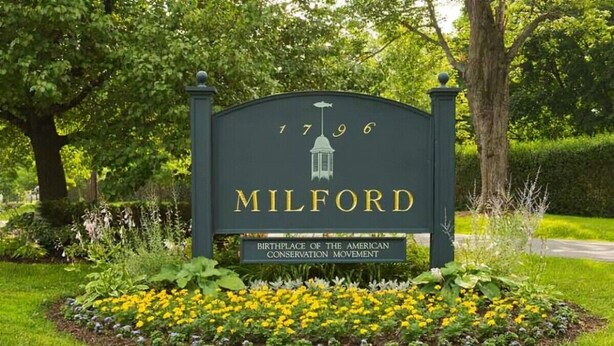 Un letrero con el año 1796 y la palabra 'MILFORD', junto con un icono de farol.