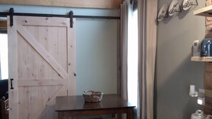 Una cocina con armarios de madera, encimera de granito, un lavamanos y una zona de comedor con una mesa y sillas.