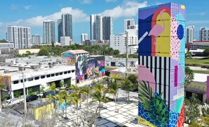 Experience the city's vibrant energy in this urban oasis with a colorful mural, modern high-rise buildings, and a tranquil pool area.