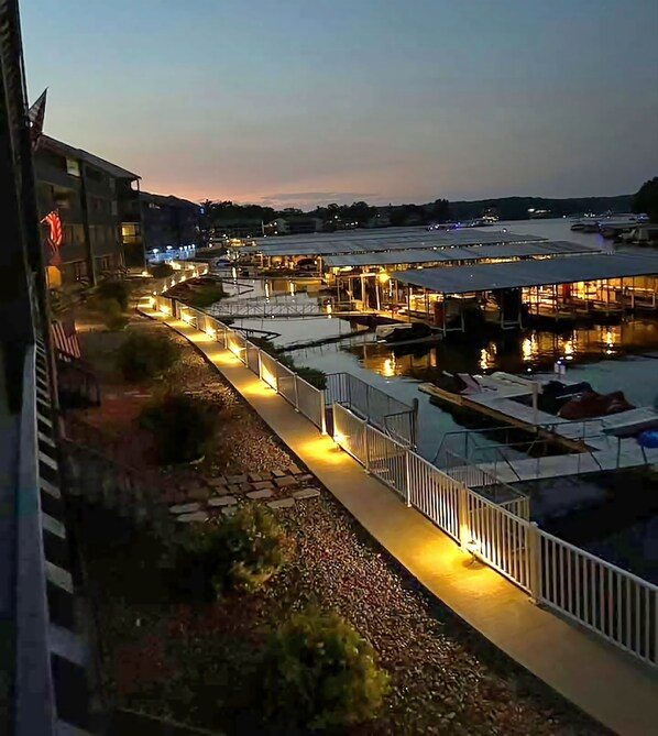 A waterfront hotel with outdoor seating areas, a covered walkway, and boats docked nearby.