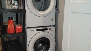 A laundry area with two stacked Whirlpool washing machines, a basket, and a bottle of Bounce detergent. - Completely remodeled downtown apartment!  2 large bedrooms! (Cascade)