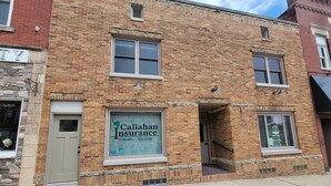 A brick building with a storefront for Callahan Insurance. - Completely remodeled downtown apartment!  2 large bedrooms! (Cascade)